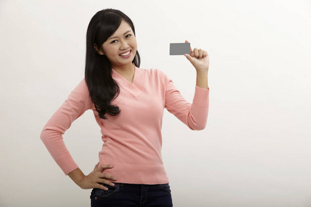 持有白色背景信用卡的亚洲女性
