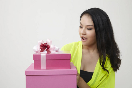 一幅美丽的女孩的肖像，手里拿着一个孤立在白色背景上的礼品盒