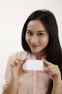 妇女显示空空白纸卡标志与复制空间的文本。 白色背景上分离的女性模型。