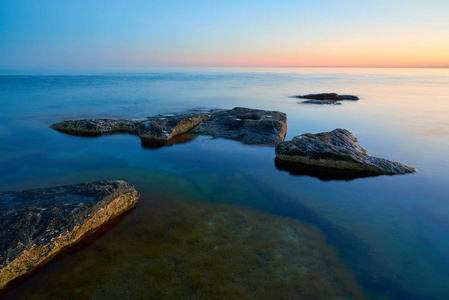 海的海岸，日落时有石头。在里海的海岸。里海是地球上最大的封闭内陆水体。