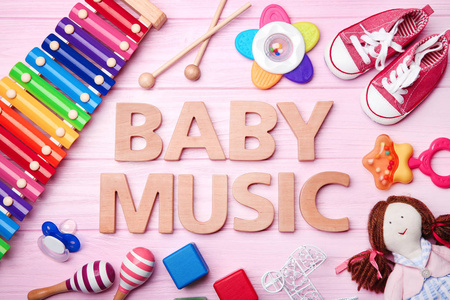 文本婴儿音乐和玩具在木背景