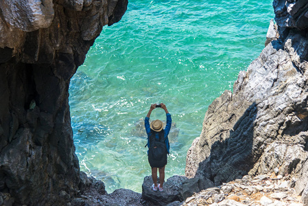 旅游人员，女游客，在泰国科西昌海边的一个山洞里拍照。 旅行