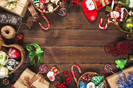圣诞背景与礼物，玩具和姜饼饼干在旧的木制背景。