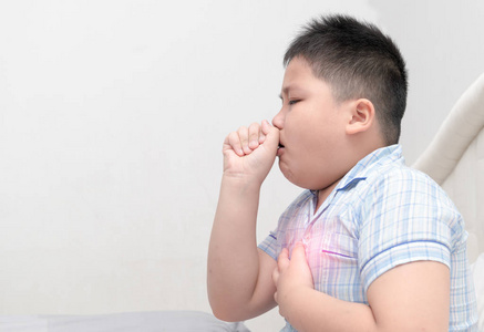 生病的肥胖男孩咳嗽和喉咙感染