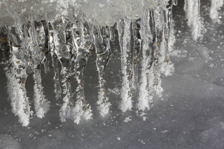 冰柱在冰冷的河上的石头上