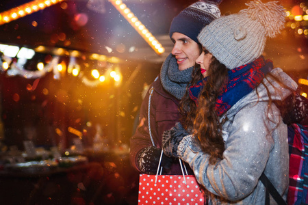 情侣购物袋在传统的圣诞市场, 假日购物