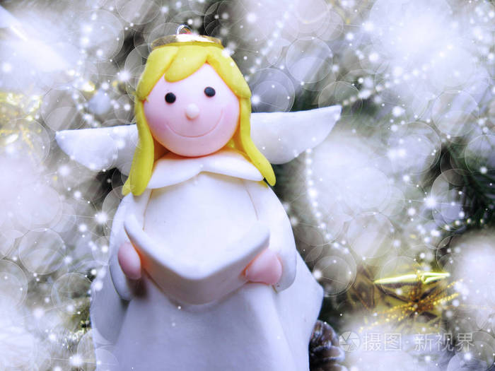 愉快的天使在圣诞节背景与花环灯