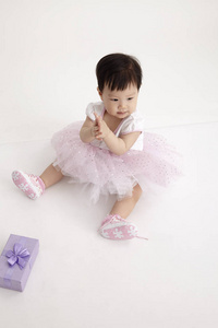 中国婴儿穿着紫色礼品盒的派对礼服