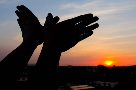 一个手势的轮廓,就像一只在夕阳下飞翔的鸟照片