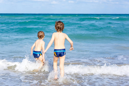 在佛罗里达州的海滩上运行的两个孩子男孩