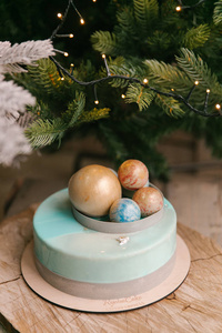 近景圣诞蛋糕，上面放着巧克力球，背景上放着冷杉