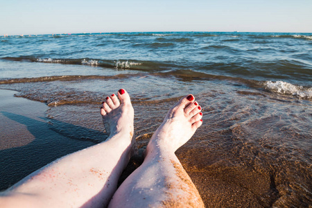 夏天的女性脚和海浪