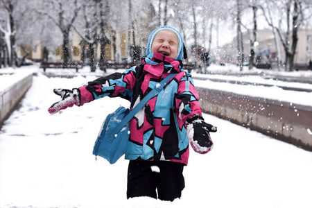 一个笑的小女孩在玩雪