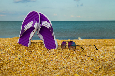 沙滩沙滩上的一双拖鞋和太阳镜