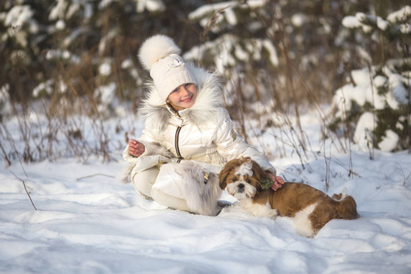 一个女孩和一只小狗狗的冬天肖像。