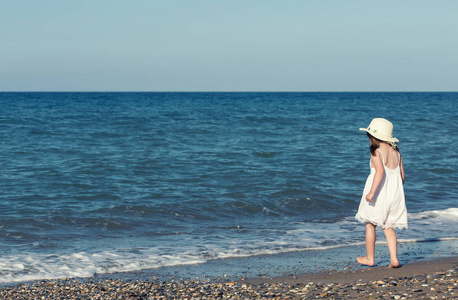 大海独自一人白色礼服走大海独自一人在海边玩耍的小女孩照片