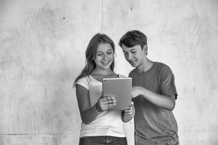快乐的青少年情侣阅读平板电脑, 在白色 backgro
