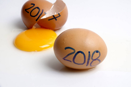 破鸡蛋与2017年书面和2018年欢迎年。 快乐的新年概念。