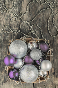 紫色的圣诞球和银, 珠子躺在一个木篮子