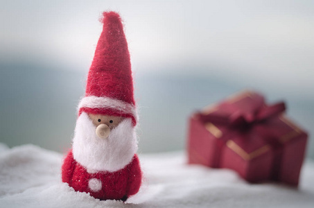 红色圣诞节礼物箱子和冷杉树在雪。圣诞节家庭装饰与雪和树在模糊的背景在白天与复制空间。选择性焦点