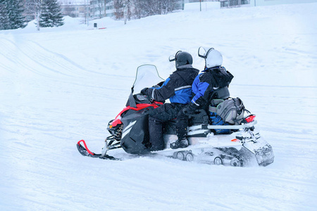 冬季罗瓦涅米雪湖骑雪地车的人们