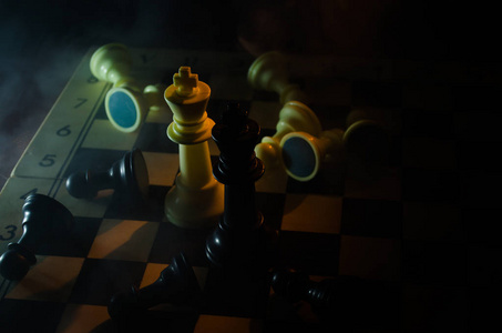 棋盘游戏的商业理念和竞争与战略理念。 在烟雾和雾的黑暗背景上的国际象棋人物。 选择性聚焦