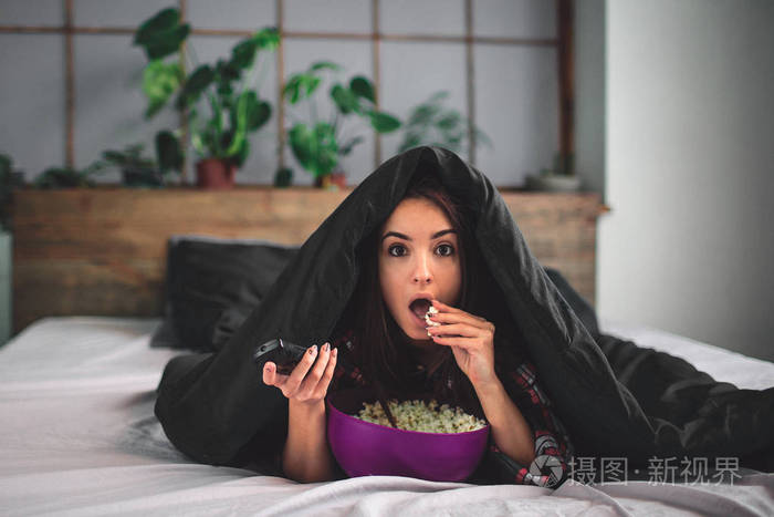 家中的年轻女子沙发沙发在客厅里看电视恐怖恐怖电影或悬疑惊悚片或