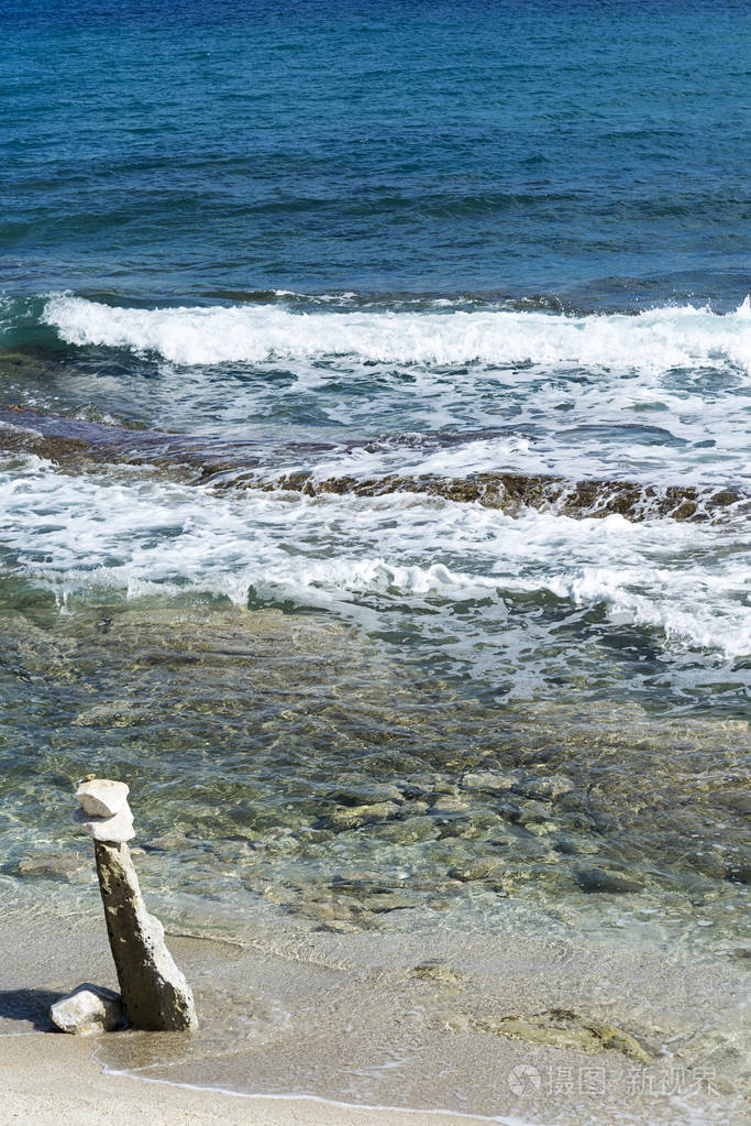 海浪在多石的海滩上,形成一朵浪花.波和溅上海滩.岩石上的海浪