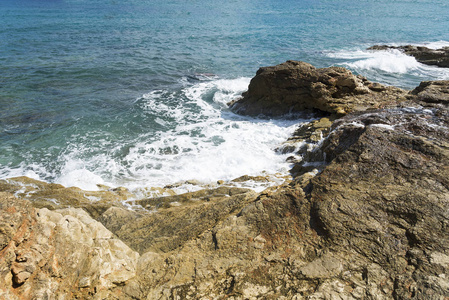 海浪在多石的海滩上，形成一朵浪花。波和溅上海滩。岩石上的海浪
