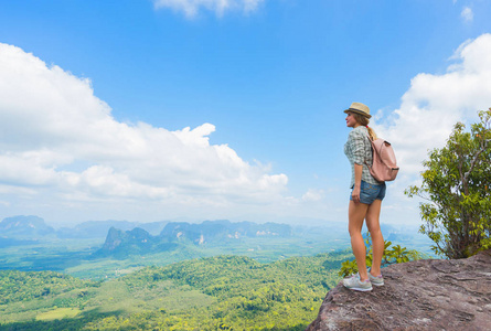 山顶上的徒步旅行者。 旅游旅行与背包和帽子在国家公园。 女人在山谷里看着美丽的岩石。 旅行概念。