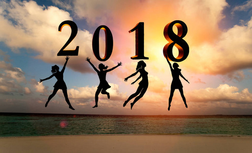 新年快乐卡片2018。剪影女性跳跃在热带海滩上的海洋和2018年的数字与日落背景