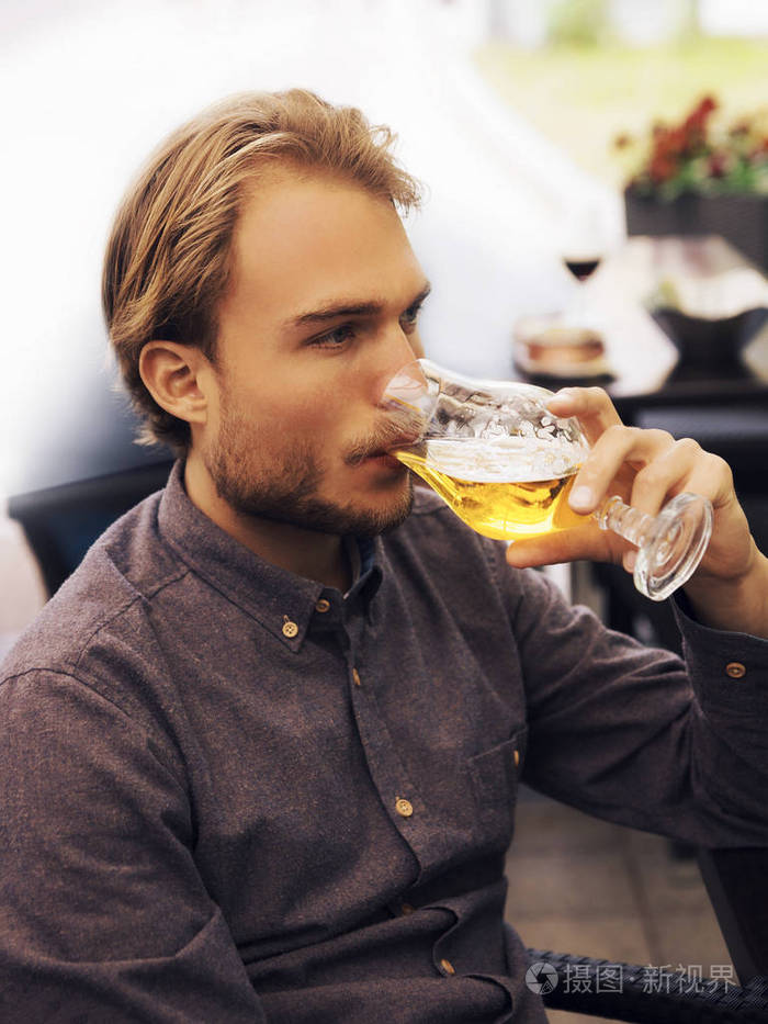 青年男子在街头酒吧喝啤酒