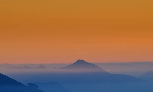 日出时雾中的小山