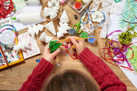 孩子们制作工艺品和玩具, 圣诞树等。画水彩。顶部视图。艺术品工作场所与创意配件。平躺艺术工具