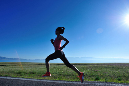 年轻的健身运动女子在乡间小路上奔跑