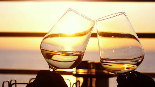婚礼时光人们捧着一杯酒, 在夕阳下敬酒.朋友喝白酒, 敬酒.碰杯.