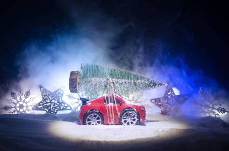 带枞树的微型车在白雪皑皑的冬天阿马特福雷斯, 或运载一棵圣诞树的玩具车和在夜时间