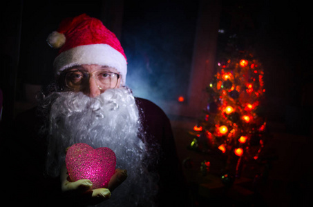 圣诞老人看着相机与传统背景。圣诞老人带来礼物为圣诞节和休息。选择性焦点
