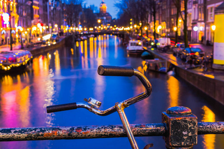 阿姆斯特丹运河和桥梁的夜间照明与典型的荷兰房子小船和自行车