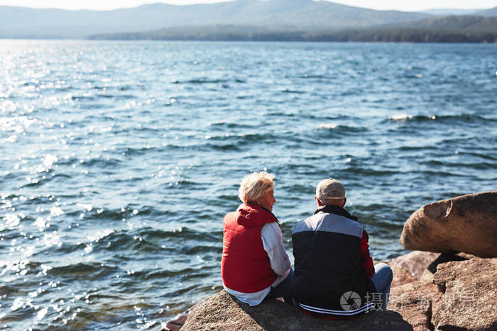 老两口坐在湖边的石头上聊天照片-正版商用图片10ljky-摄图新视界