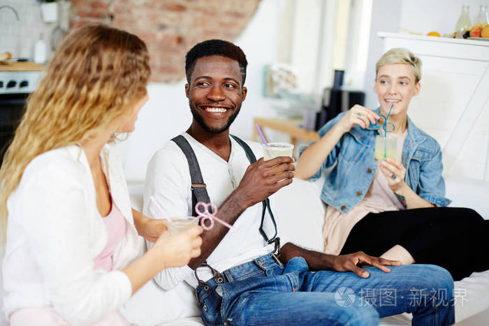 年轻人和两个带着饮料的女孩闲谈
