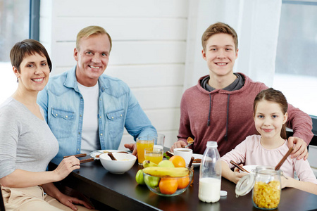 一家人坐在餐桌旁，吃着健康的有机食品