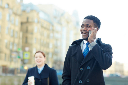 城市秋街两位商业同事的画像非裔美国人，一边打电话一边兴高采烈地笑着