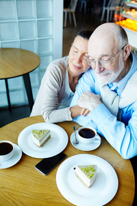 一对老夫妇一桌一桌地在咖啡馆休息