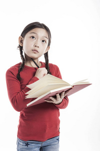 小女孩拿着一本书，站在画室里，隔着白色的背景