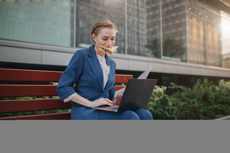 一定要吃饭表情忙碌的女人在匆忙中, 她没有时间, 她要去户外吃点心.