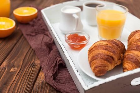 新鲜出炉的牛角面包, 橙汁, 新鲜水果, 棕色木制背景果酱。法式早餐早上的新鲜点心美味的甜点顶部视图。特写摄影。水平横幅