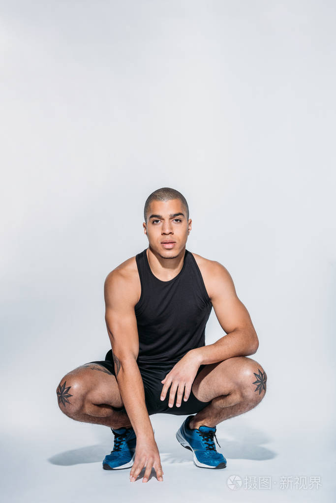 动作敏捷的非裔美国人蹲着看镜头照片-正版商用图片10lvn6-摄图新视界