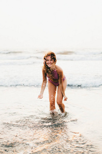 美丽的白种女人穿着湿泳装在海滩在海洋水域, 的女孩, 妇女在度假, 日落在海边, 棕榈在海滩