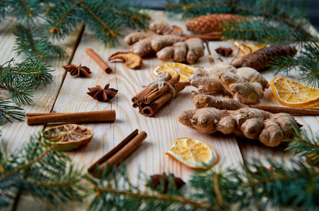 肉桂棒与八角星，生姜干橙子苹果在木制背景与圣诞树树枝。 传统香料覆盖葡萄酒圣诞面包店。 新年作文。